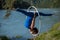 Red-haired gymnast in a blue suit doing the difficult exercises at the air ring in nature