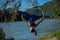 Red-haired gymnast in a blue suit doing the difficult exercises at the air ring in nature