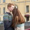 Red-haired man kisses a woman on the top of her head, a boy in a sweater soothes and comforts a girl with long dark thick hair
