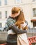 Red-haired man kisses a woman on top of her head, a boy in a sweater soothes and comforts a girl with long dark thick hair