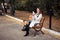 Red-haired middle-aged woman with a smartphone in her hand sits on a bench in the Park and communicates in social networks