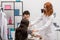 A red-haired nurse puts a blood pressure monitor on a young patient& x27;s arm. Primary care physician. Doctor& x27;s office