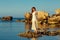 The red-haired sensual girl in a white dress standing on the sea