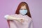 Red-haired teenage girl in a mask holds a sore finger down . the concept of prevention covid19