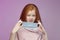 Red-haired teenage girl puts a mask on her face. the concept of prevention covid19