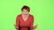 Red haired woman screams, she is aggressively attuned to her colleagues. Green screen