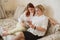 Red-haired woman teaches an elderly mother how to use a smartphone. Mother and adult daughter dressed in white blouses are sitting