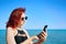 Red-haired woman writes message on her mobile phone.