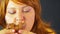 A red-haired young woman after a diet eats cakes while no one sees