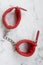 Red handcuffs for love games.Products in a sex shop, toys for adults
