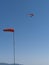 Red hang glider above with wind cone
