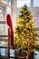 Red hat of Santa Claus hangs on background of sledges and Christmas tree