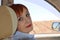 Red-headed Russian woman sitting on the seat of taxi car and looking at the camera.