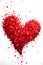 Red heart arranged with confetti on a white isolated background. New Year\\\'s fun and festiv