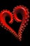 Red heart arranged from two tentacles of an octopus on a black background. Heart as a symbol of afon and love