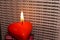 Red heart candle on the background of words about love, translated from Russian I love you in February on Valentine's Day