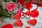 Red heart candles . Red rose petals . Gold wedding rings