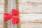 Red heart candy and burlap lace on wooden board