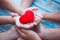 Red heart in child and parent hands with love and harmony