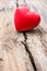 Red heart in crack of wooden plank