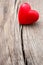 Red heart in crack of wooden plank