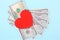 Red heart and Dollars banknotes on blue background. Business and love concept