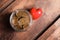 Red heart and donation jar with coins on wooden table