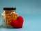 Red heart beside Fish oil capsules in glass bottles on blue background. Healthy omega-3 and stethoscope