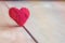 red heart handmade of wool on wooden background, a symbol of love, bright sun