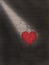 Red heart hanging on black brick wall. Textured symbol of love. Lovers symbol