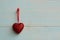 Red heart hanging on a thread on a blue wooden background