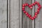 Red heart of hawthorn berries on a wooden background