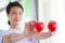 Red heart held by smiling female nurse`s hand, representing giving effort high quality service mind to patient. Professional