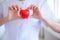 Red heart held by smiling female nurse`s hand, representing giving effort high quality service mind to patient. Professional, Spec