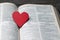 The red heart on holy bible book is the symbol of love from God. The God gives love to all people. We can see or find bible at the