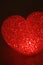 Red heart of led light over dark background