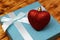 A red heart lies on a turquoise gift box