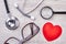 Red heart, loupe and stethoscope.