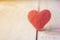 Red heart made of wool on wooden background, a symbol of love, bright sun