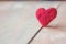 red heart made of wool on wooden background, a symbol of love, bright sun