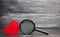 Red heart and magnifying glass. Concept of love and relationships. Search for love. Valentine`s Day. Loneliness. Find a donor for