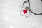 Red heart and a medical stethoscope, insurance,hospital,world health day concept top view on white wooden background