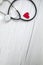 Red heart and a medical stethoscope, insurance,hospital,world health day concept top view on white wooden background