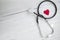 Red heart and a medical stethoscope, insurance,hospital,world health day concept top view on white wooden background