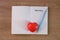 Red heart on notebook with part one word and a pencil on wooden background.  Valentine`s Day concept