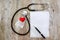 Red heart, notepad, pills and stethoscope. Health concept. View from above.