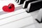 Red heart ornament with ladybug on piano keyboard