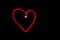 Red heart outline light painting in black night sky