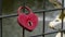 Red heart padlock locked to a bridge