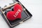 Red heart in a rat trap on white wooden background. Online internet romance scam or valentine day in darkside concept.